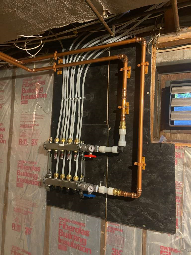 Heated floor manifold plumbing installation for radiant floor heating