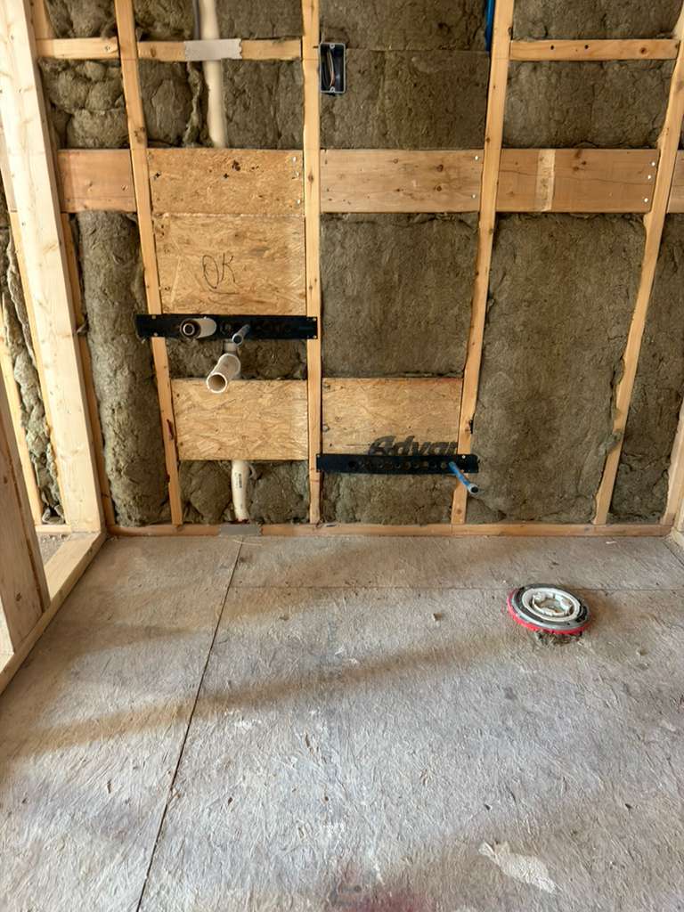 Sink and toilet installation during bathroom rough-in plumbing stage